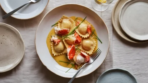 Na imagem, há um prato com ravioli recheado com molho de tomate e coberto com algumas folhas de manjericão